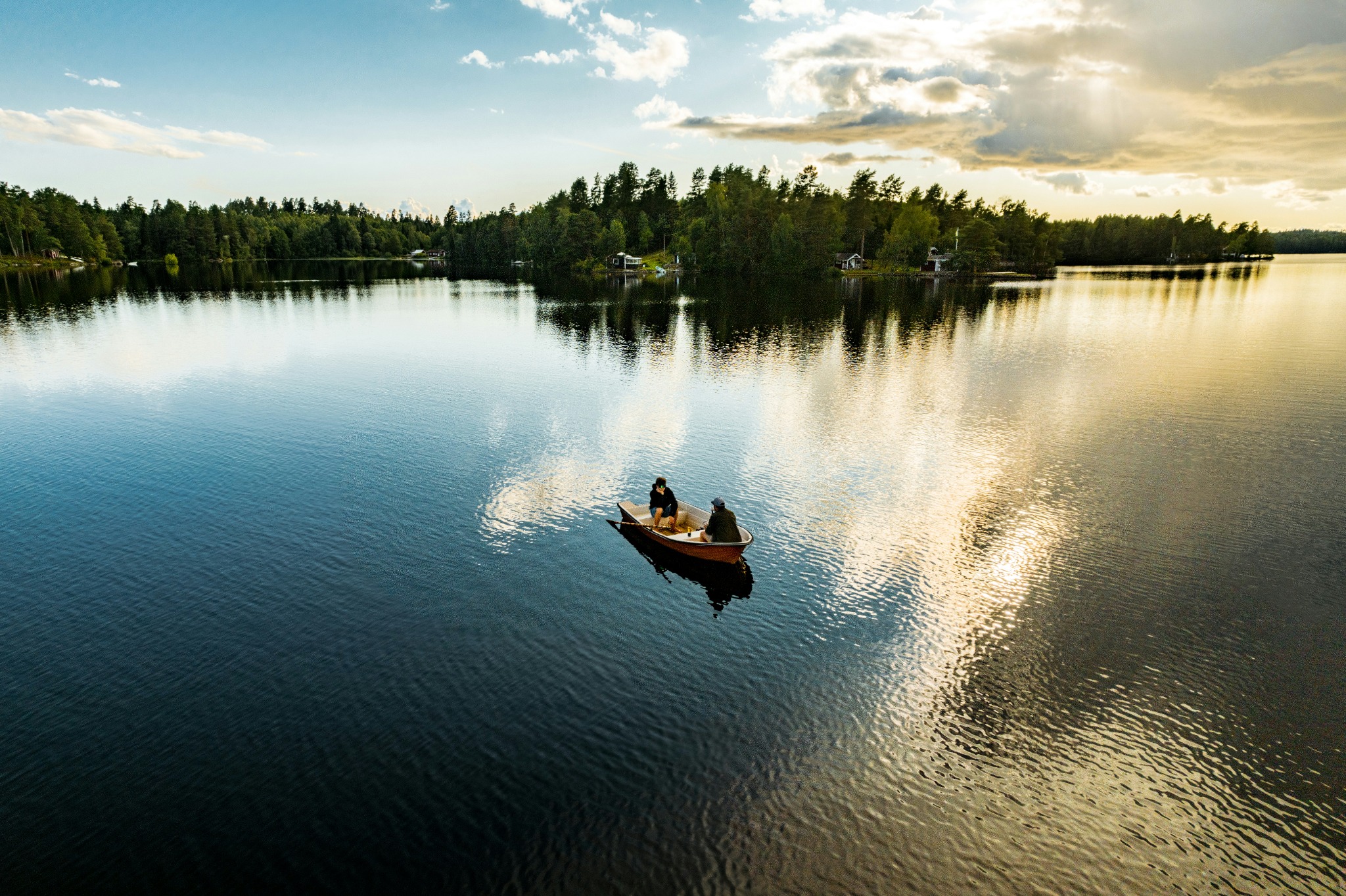 A small boat crossing a calm Swedish lake